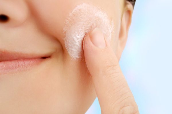Woman Applying Exfoliating Face Cream