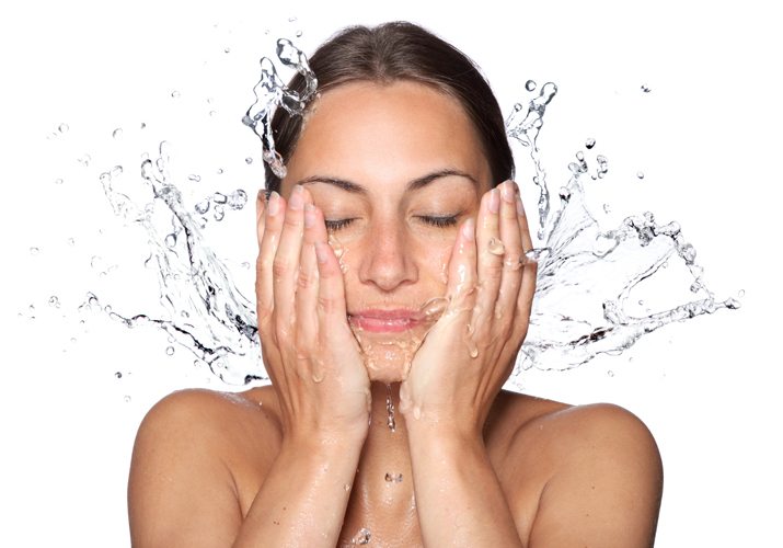 Women splashing water on her face after using Clarisonic to cleanse her skin