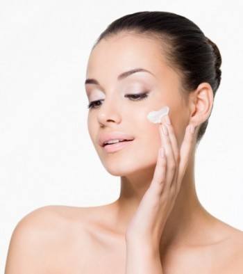 women applying moisturizer to her face 