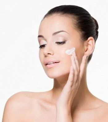 women applying moisturizer to her face