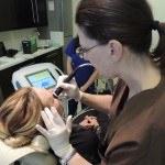 Esthetician using thermismooth facial treatment on client's under eyes