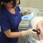 Esthetician using thermismooth body treatment on client's bicep
