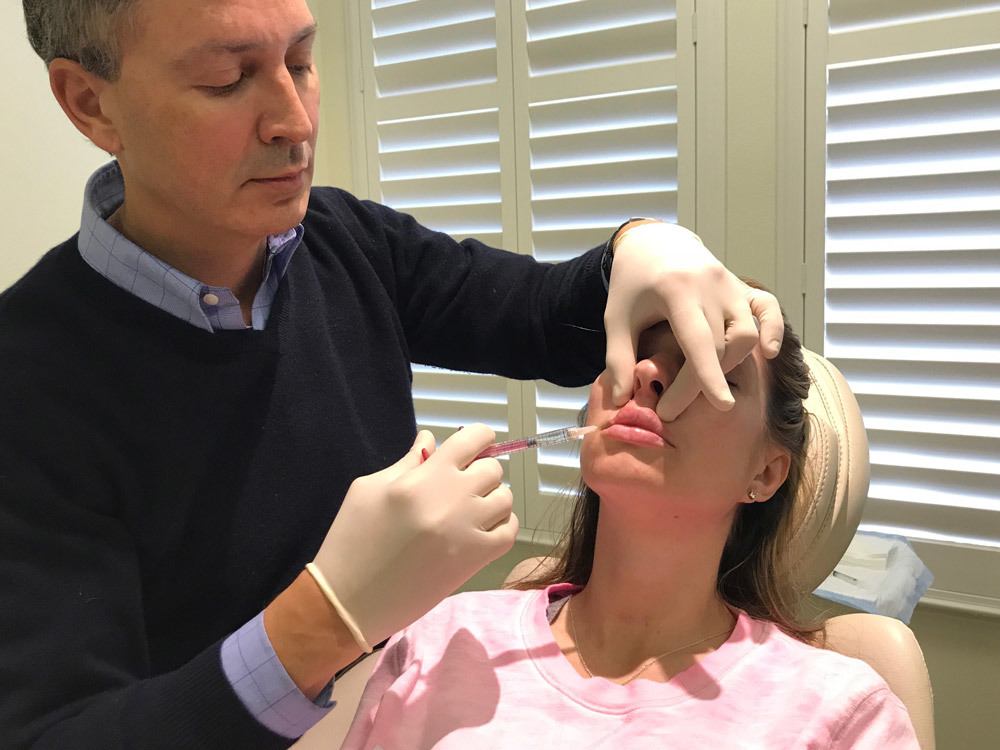 dr. victor lacombe injecting restylane fillers into woman's lips
