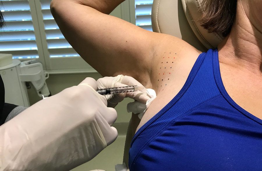 specialist injecting Kybella treatment into underarm of women to remove fat and bra bulge