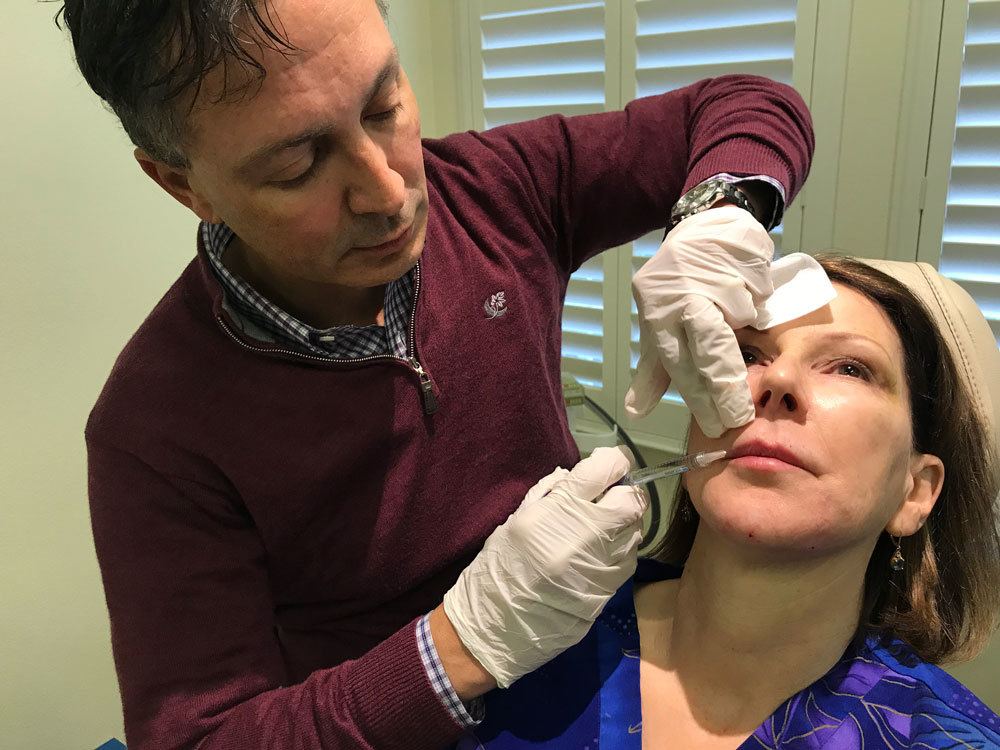 dr. victor lacombe injecting juvederm voluma fillers into woman's lips