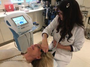 esthetician administers thermismooth to patient's forehead