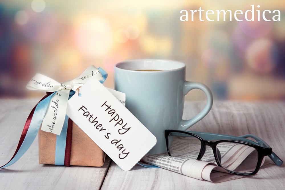 Table top with wrapped gift, coffee cup, and reading glasses on father's day.