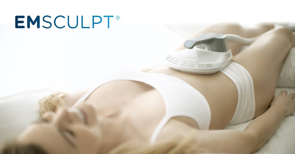 Woman lying down receiving emsculpt treatment.