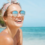 Young blonde woman wearing sunglasses on beach