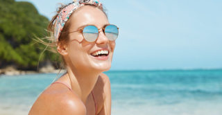 Young blonde woman wearing sunglasses on beach