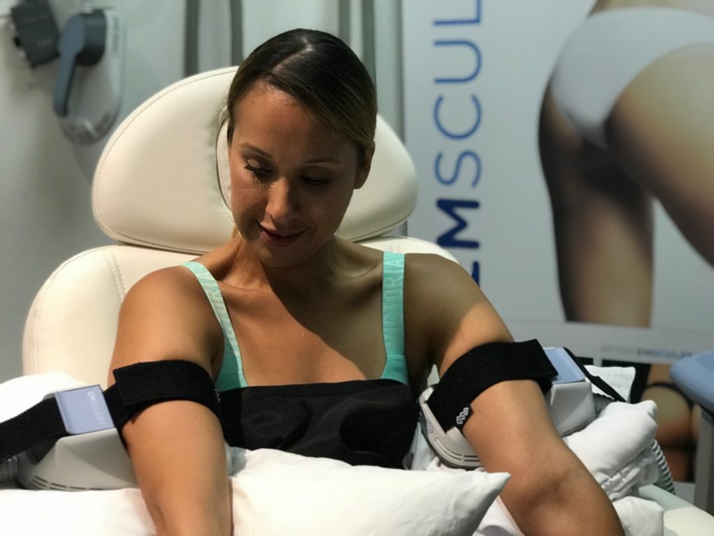 woman receiving emsculpt procedure on her arms