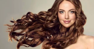 Beauty brunette women with long and thick and healthy shiny wavy hair . B