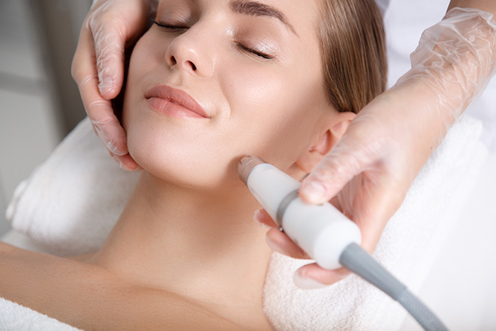 women laying down looking peaceful while having laser skin treatment on her face