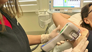 Esthetician using MiraDry treatment on client's armpit