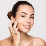 women applying skincare product to face to help enhance the long-term results of a cosmetic treatment