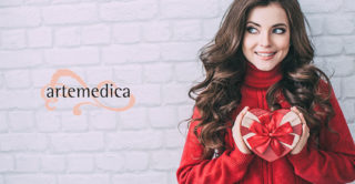 beautiful women in red sweat, smiling and holding a heart shaped valentine's day gift box