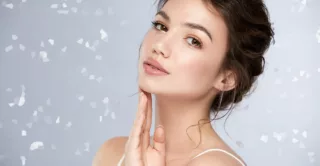 a close up of a beautiful, young, woman's face with glossy lips and light make-up looking to camera, elegant and natural girl