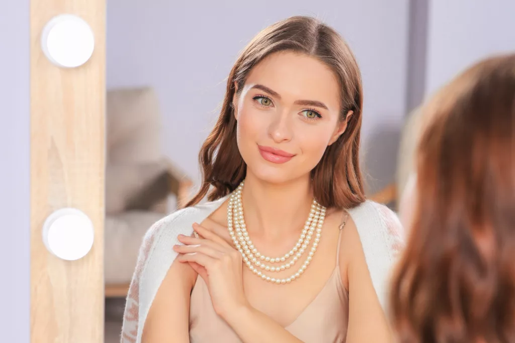 young woman with full, perfect lips admires her appearance in the mirror as she gets ready to go out