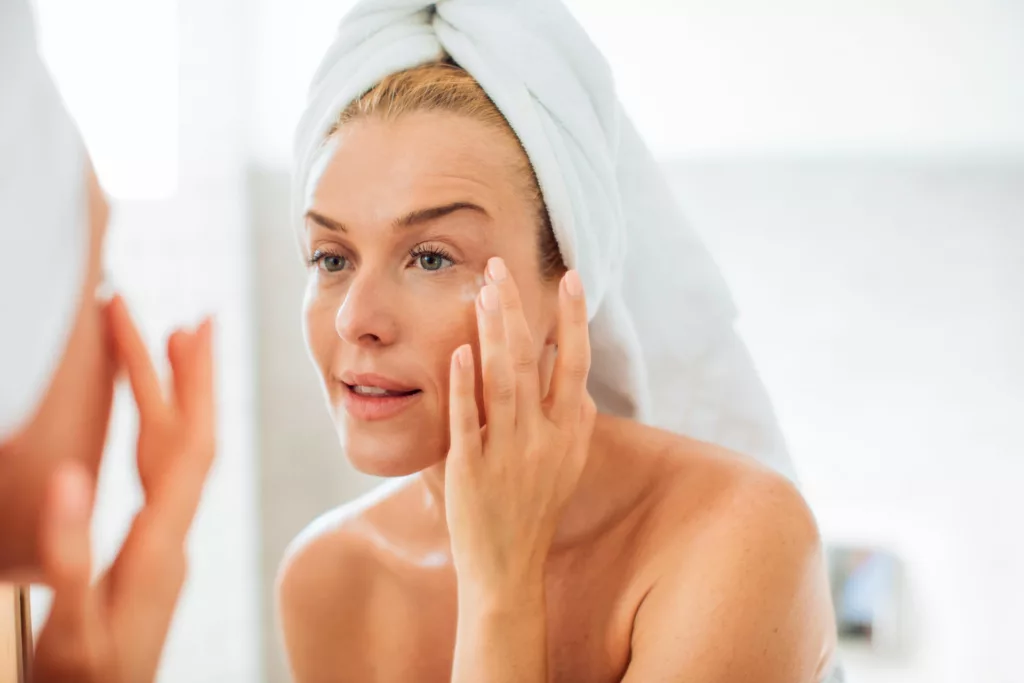 beautiful mature woman admires her appearance in the mirror