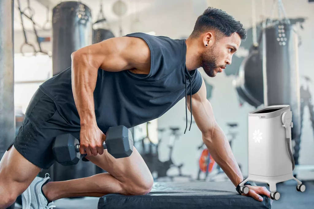 young man lifts weights at the gym, focusing on his biceps and triceps