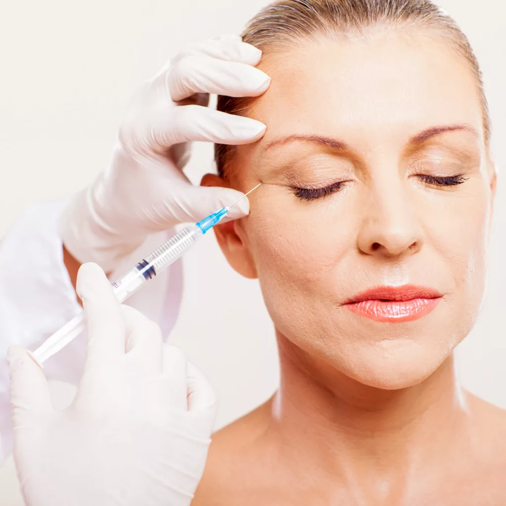 licensed provider injecting cosmetic filler into a woman's crows feet