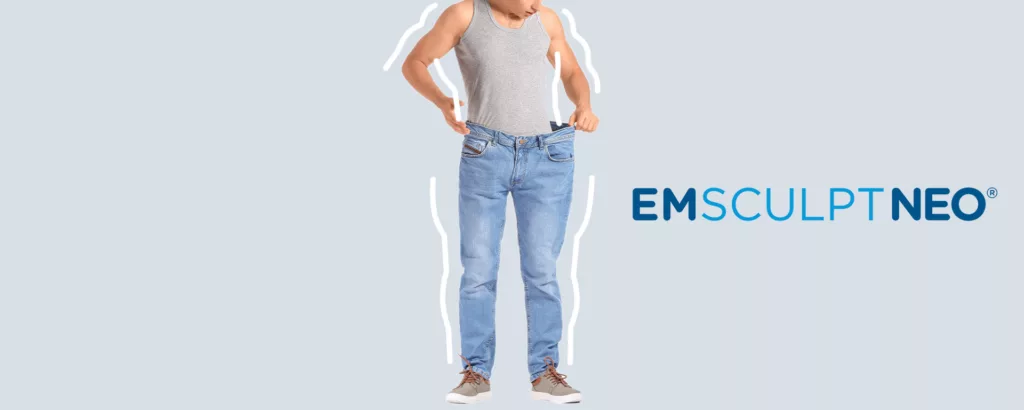 man in too large pair of jeans shows off all the weight he's lost and muscle he's gained with emsculpt neo
