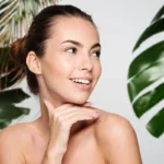 Woman with healthy skin smiling white a blurred tropical themed background