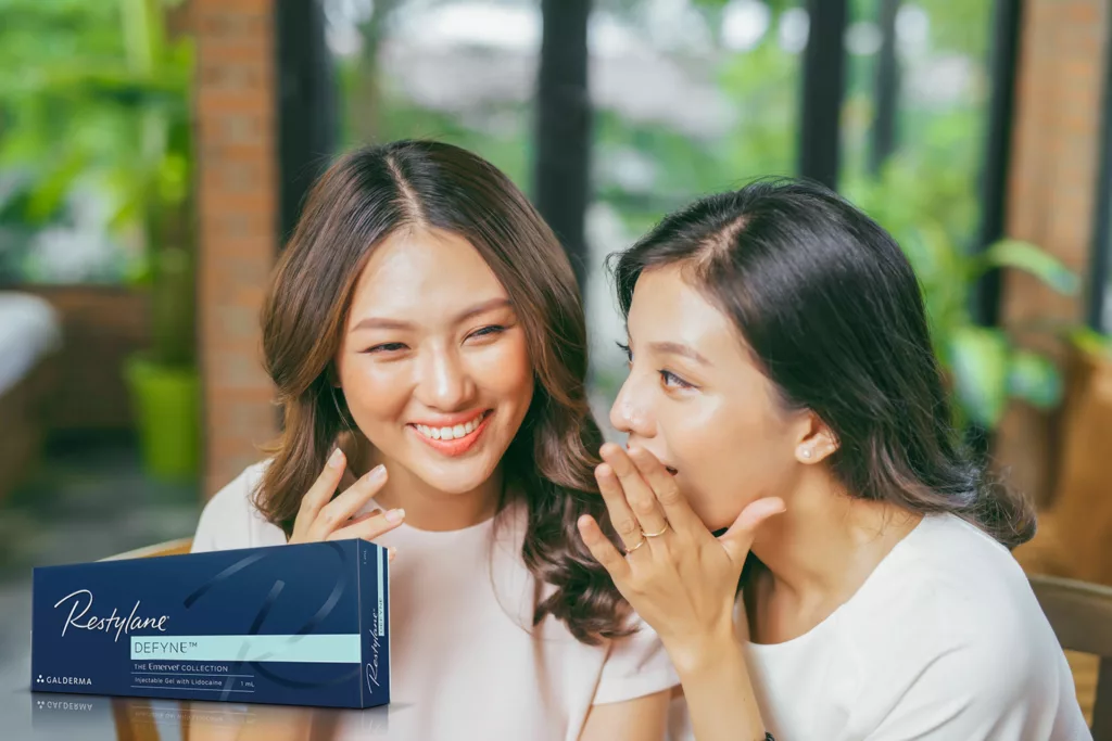 two lovely asian women smile, laugh and talk outside a quaint cafe