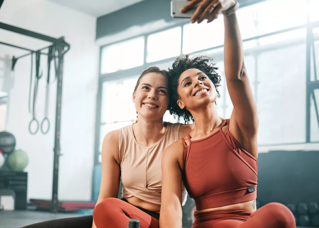 Two women take a selfie, smiling after EmSculpt Medical Gym treatments.