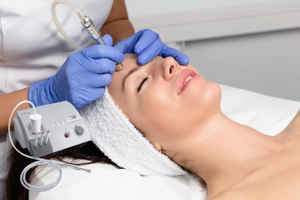 woman receiving a microdermabrasion treatment by a trained aesthetician