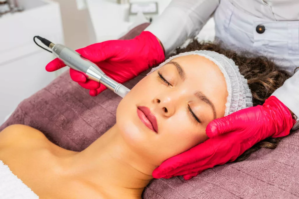 woman receiving microneedling treatment from a licensed aesthetician at a medical spa