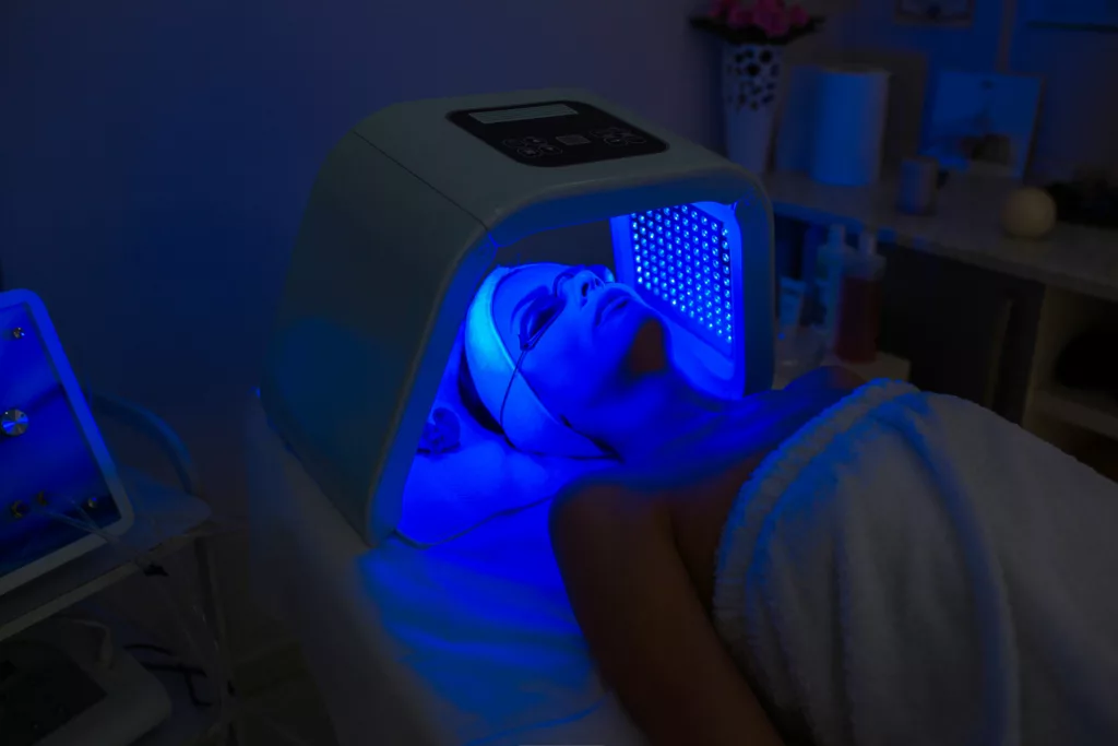 woman receives blue light therapy at a medical spa