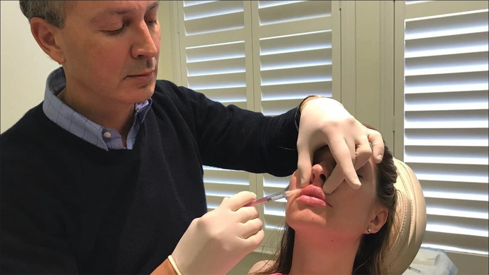 Dr. Victor Lacombe injecting a client with Juvederm Filler in her lips