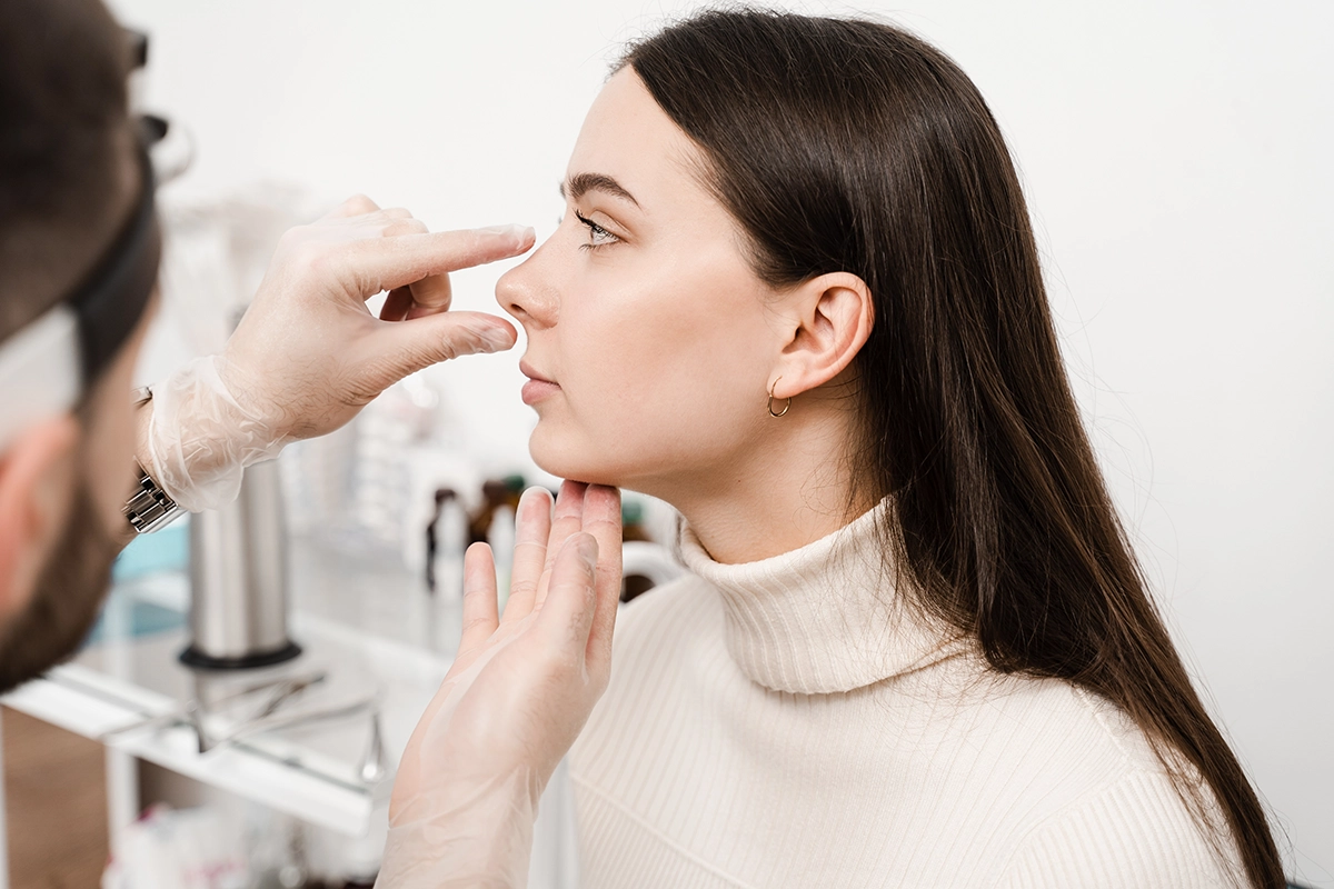 A board-certified facial plastic surgeon gives a patient a consultation